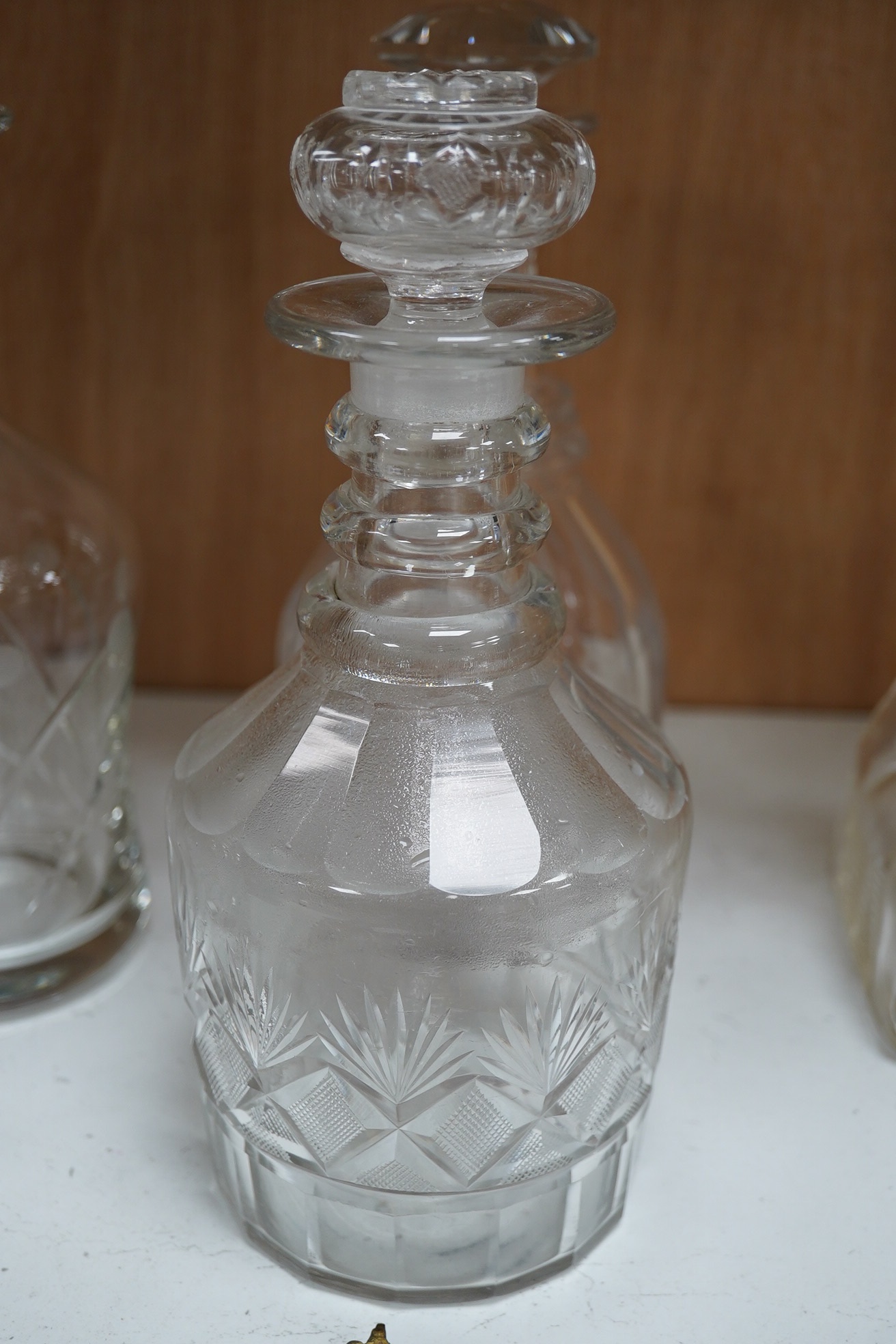 Six 19th century and later cut glass decanters and stoppers, one with white metal acorn design collar, largest 37cm high. Condition - fair, some chipping / impact damage